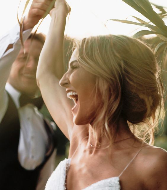 Bride dancing with arms raised